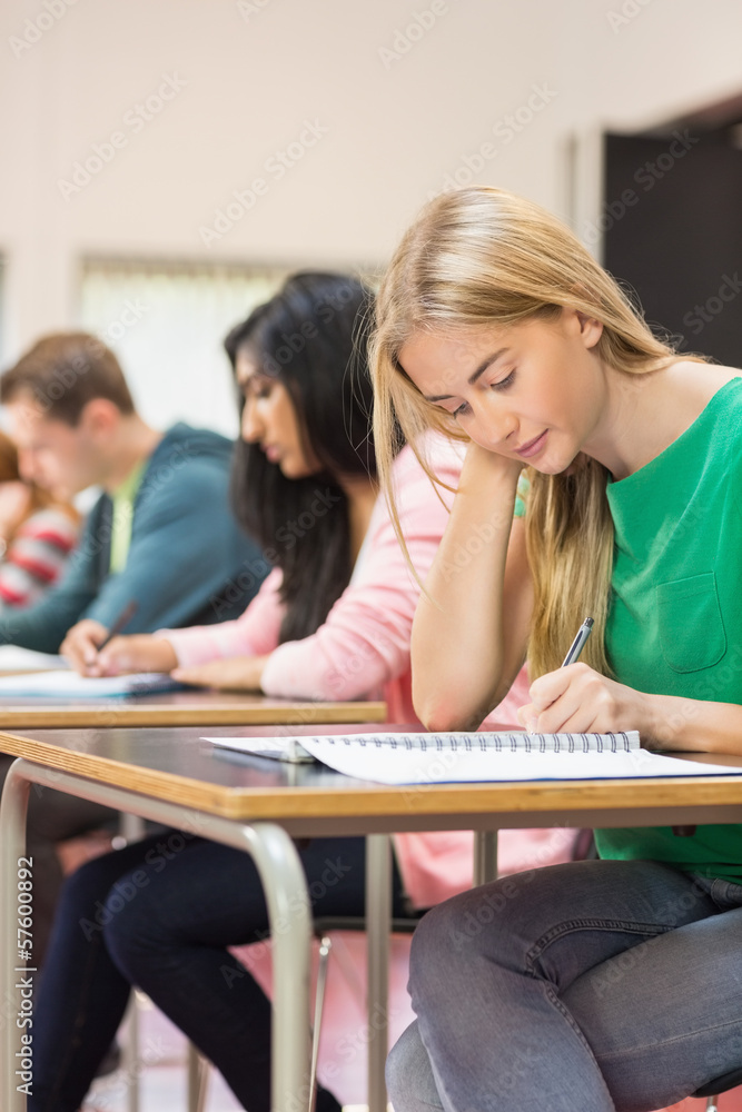 Students writing notes in classroom Students writing notes in classroom