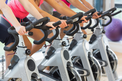 Mid section of people working out at spinning class photo