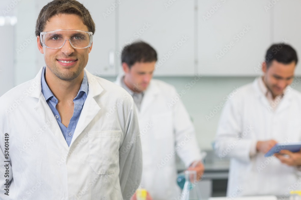 Smiling scientist with colleagues at work in the lab Smiling scientist with colleagues at work in the lab
