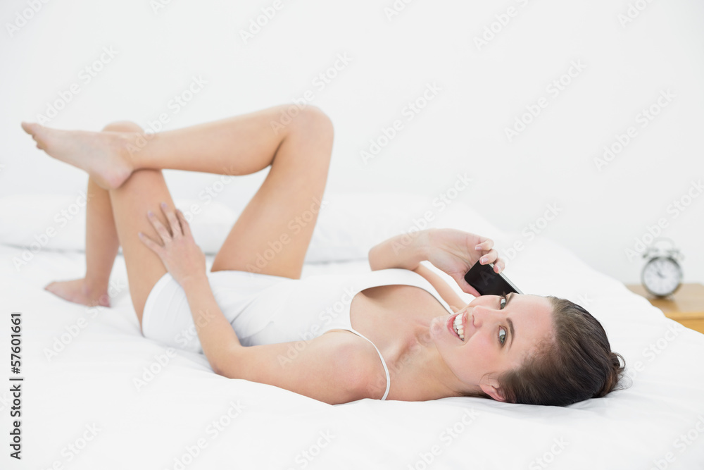 Portrait of a woman using mobile phone in bed