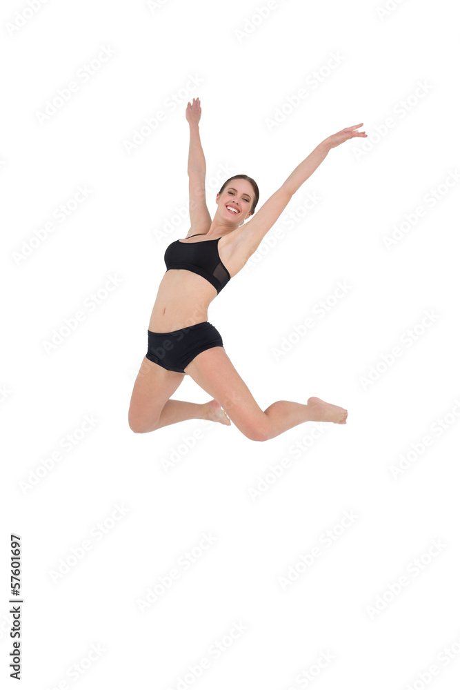 Smiling sporty woman jumping on white background Smiling sporty woman jumping on white background