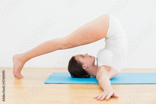 Side view of a woman exercising on mat