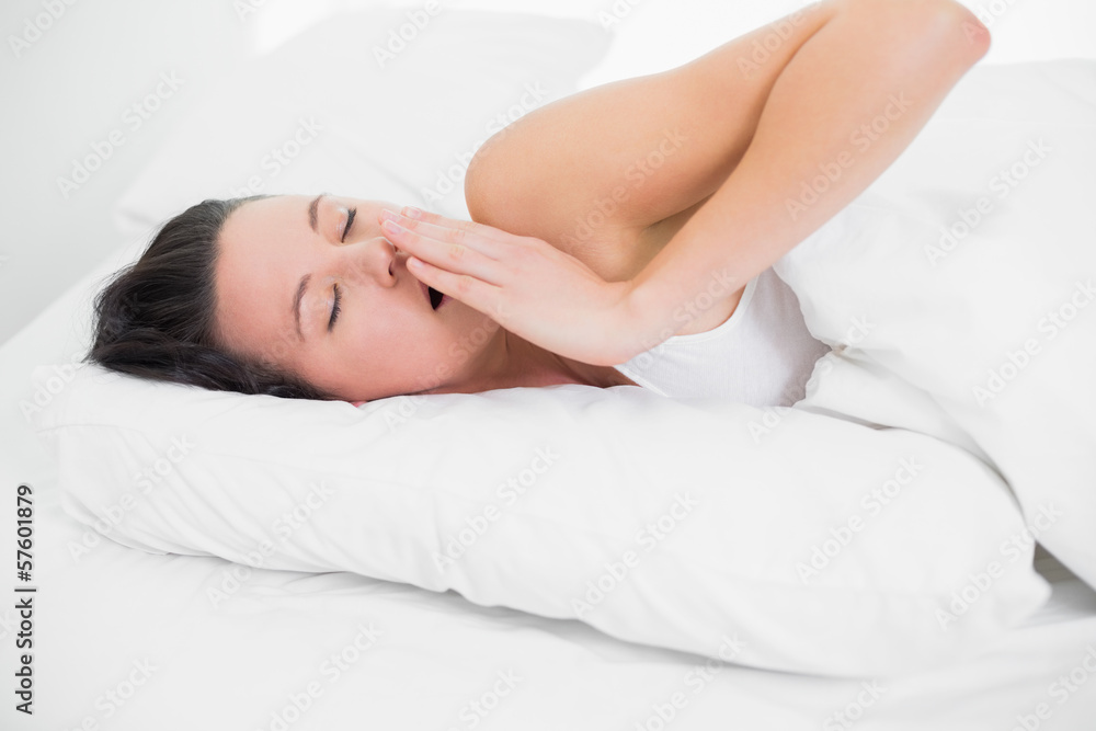 Beautiful woman yawning in bed with eyes closed Beautiful woman yawning in bed with eyes closed