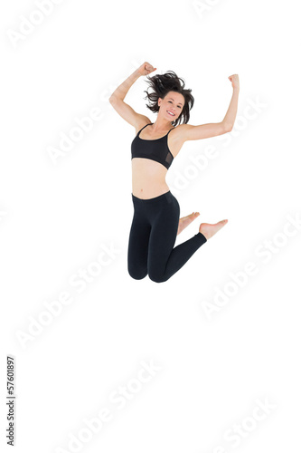 Sporty young woman jumping over white background