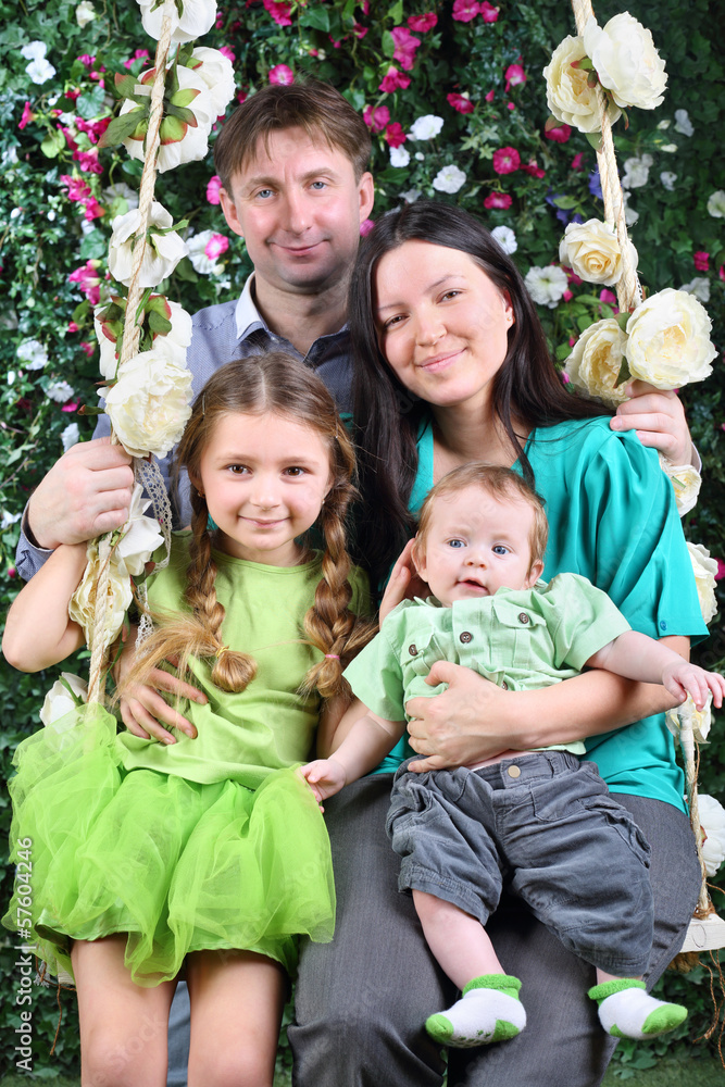 Happy father and mother with baby and little daughter Happy father and mother with baby and little daughter
