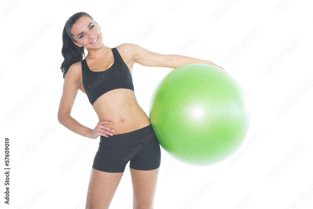 Attractive fit woman posing holding a green exercise ball Attractive fit woman posing holding a green exercise ball