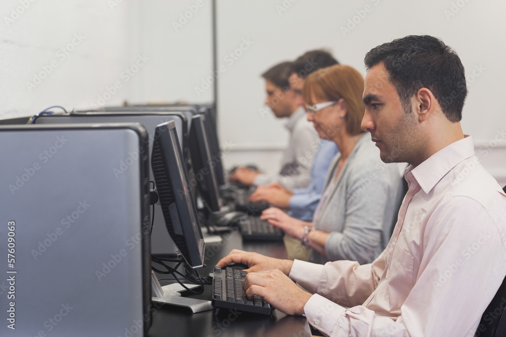 Mature students sitting in computer class Mature students sitting in computer class