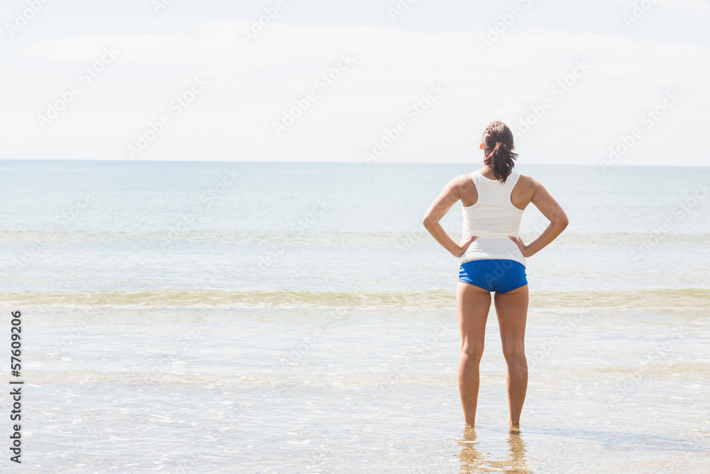 Slender fit woman standing on the beach Slender fit woman standing on the beach