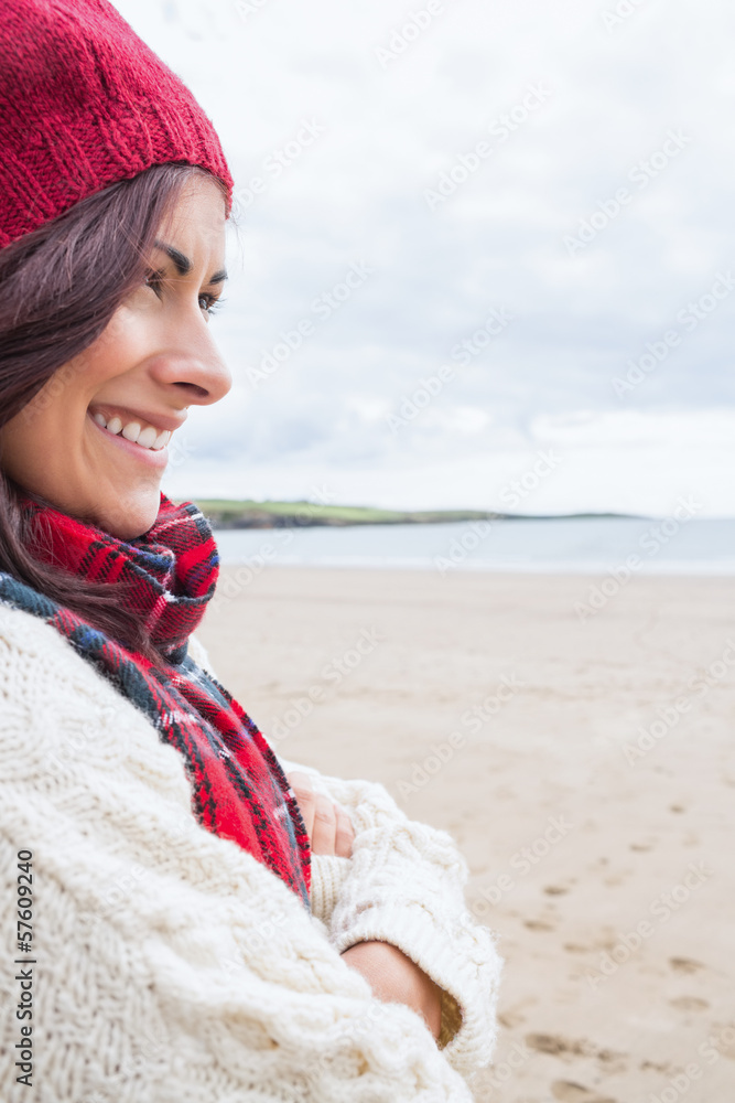 Woman in knitted hat and pullover smiling at beach Woman in knitted hat and pullover smiling at beach