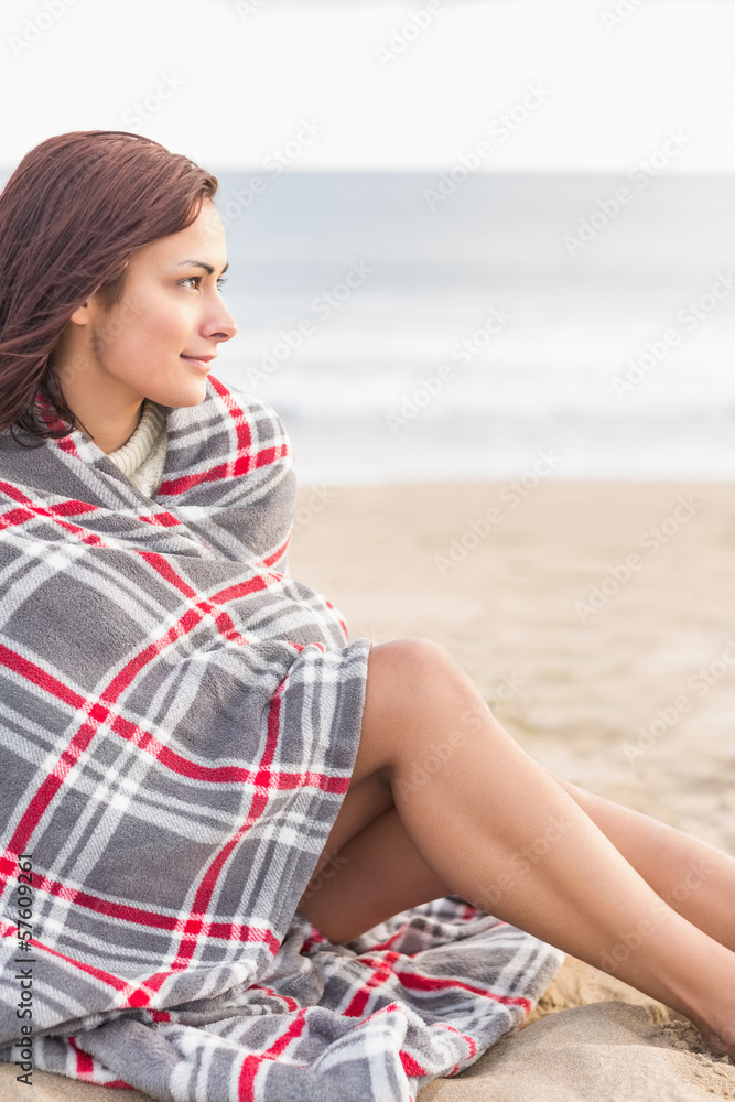 Fototapeta premium Woman covered with blanket at beach