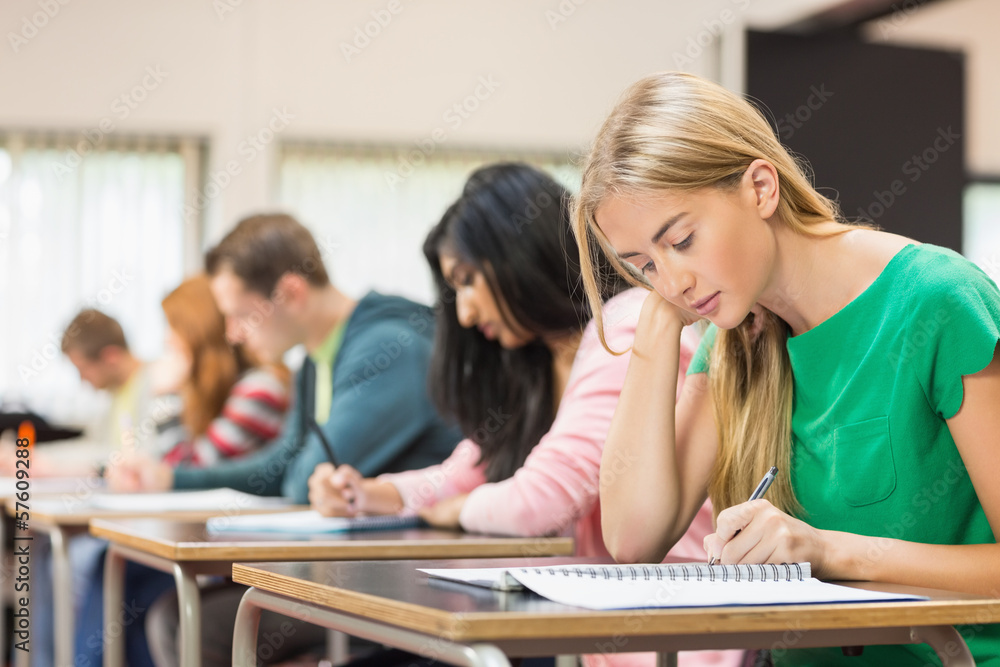 Young students writing notes in classroom Young students writing notes in classroom