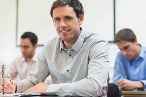 Mature students taking notes in classroom