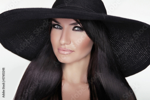Fashion brunette woman model posing in black hat isolated on whi © Victoria Andreas