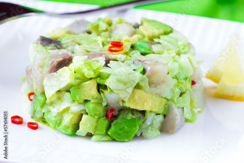 Elegant salad Tartar with herring, avocado, lettuce, restaurant