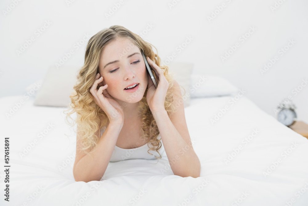Pretty content blonde lying on bed phoning Pretty content blonde lying on bed phoning
