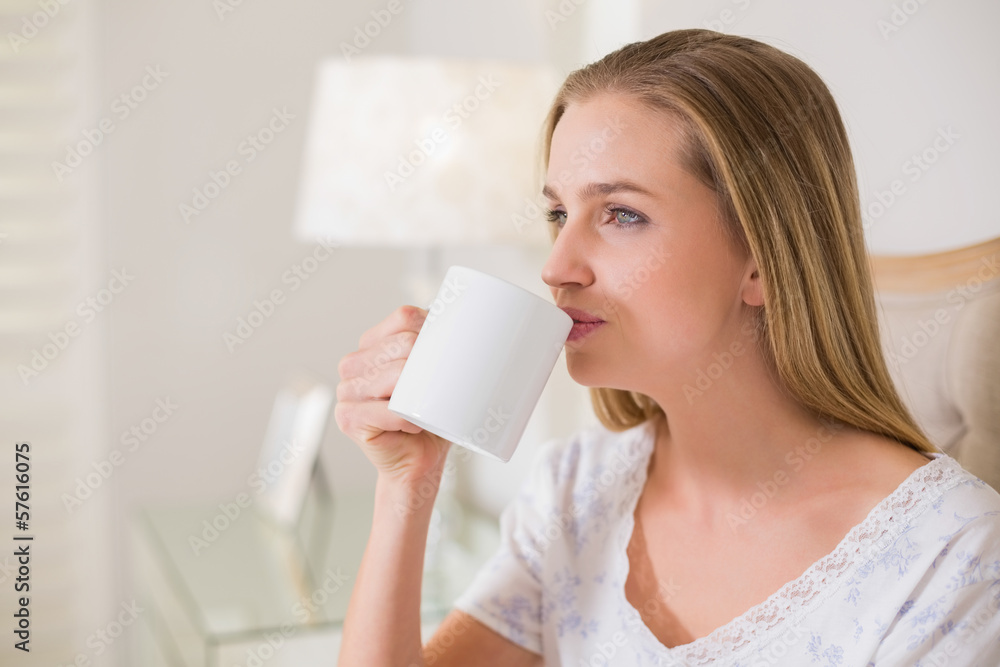 Natural content woman sitting on bed drinking Natural content woman sitting on bed drinking