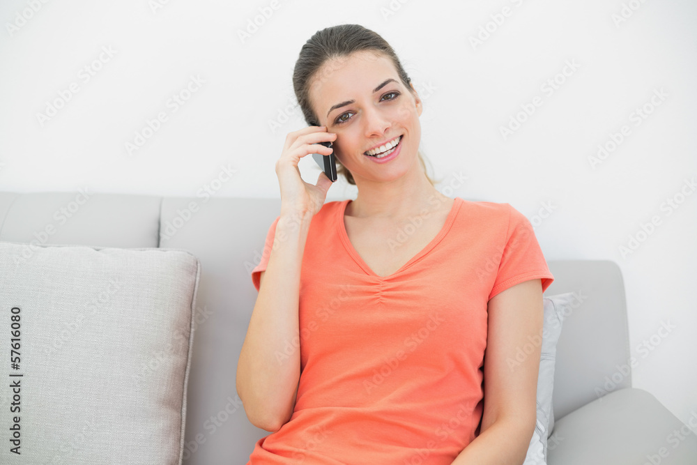 Pretty casual woman phoning with her smartphone sitting on couch Pretty casual woman phoning with her smartphone sitting on couch