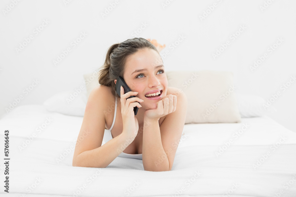 Smiling casual woman using mobile phone in bed Smiling casual woman using mobile phone in bed