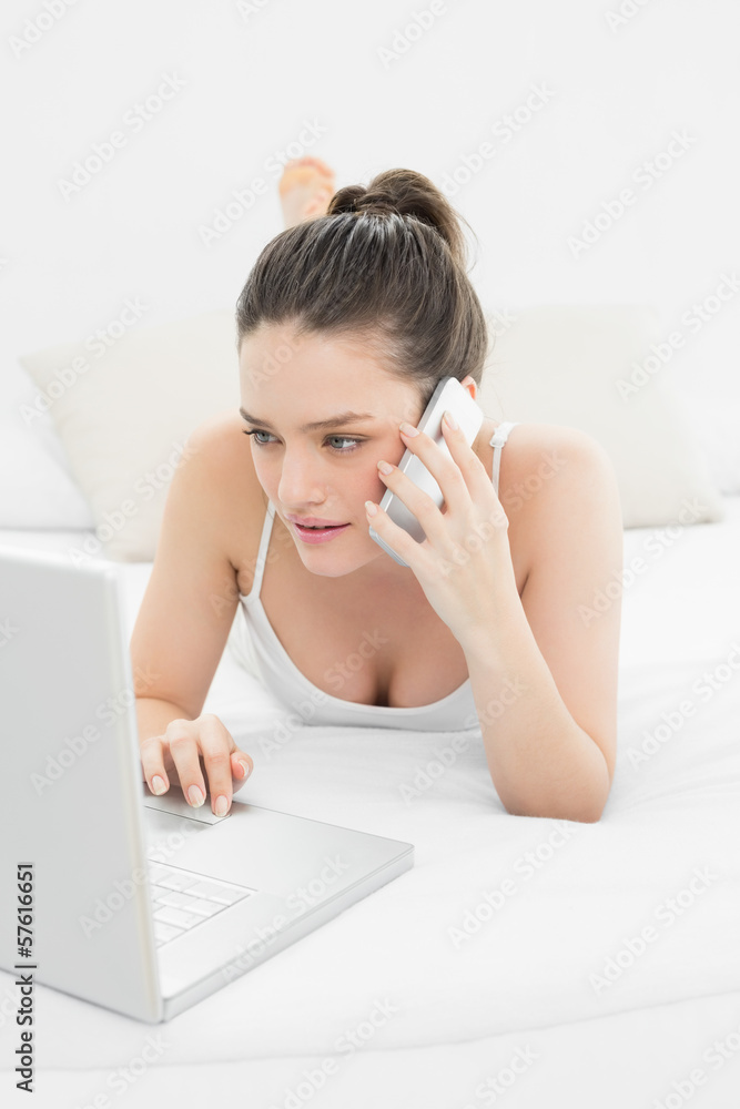 Serious casual woman using cellphone and laptop Serious casual woman using cellphone and laptop