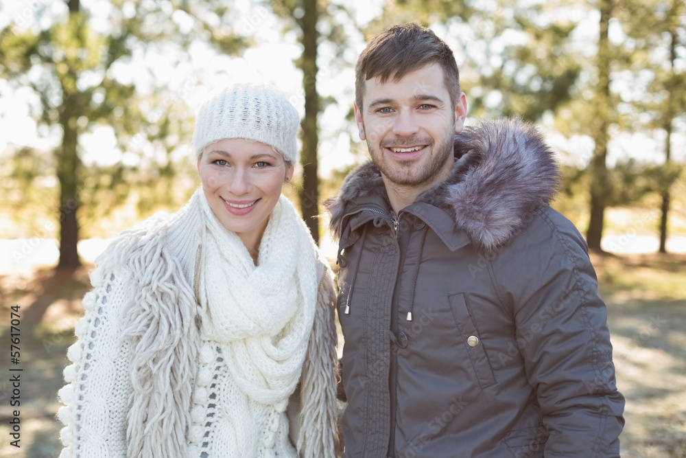 Smiling couple in winter clothing in the woods