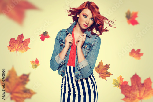autumn picture of young beautiful red haired girl with leaves