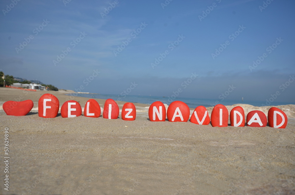 Obraz premium Feliz Navidad on colourful stones on the sand