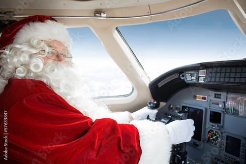 Santa Holding Control Wheel In Cockpit Of Private Jet