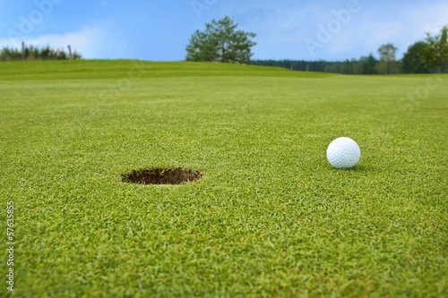 Golf, ball lying on the green next to hole