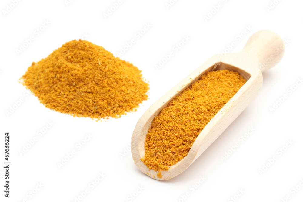 Orange curry on wooden spoon. Isolated on white background Orange curry on wooden spoon. Isolated on white background