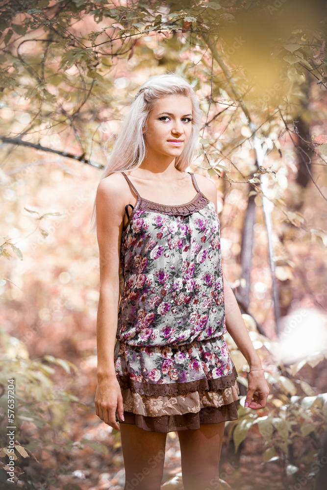 Blonde girl posing in short dress at autumn forest Blonde girl posing in short dress at autumn forest