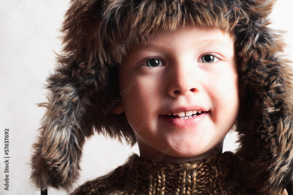 smiling child in a fur hat.fashion boy.winter style.children smiling child in a fur hat.fashion boy.winter style.children
