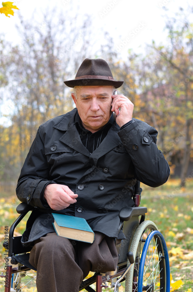 Elderly disabled man in a wheelchair in a park