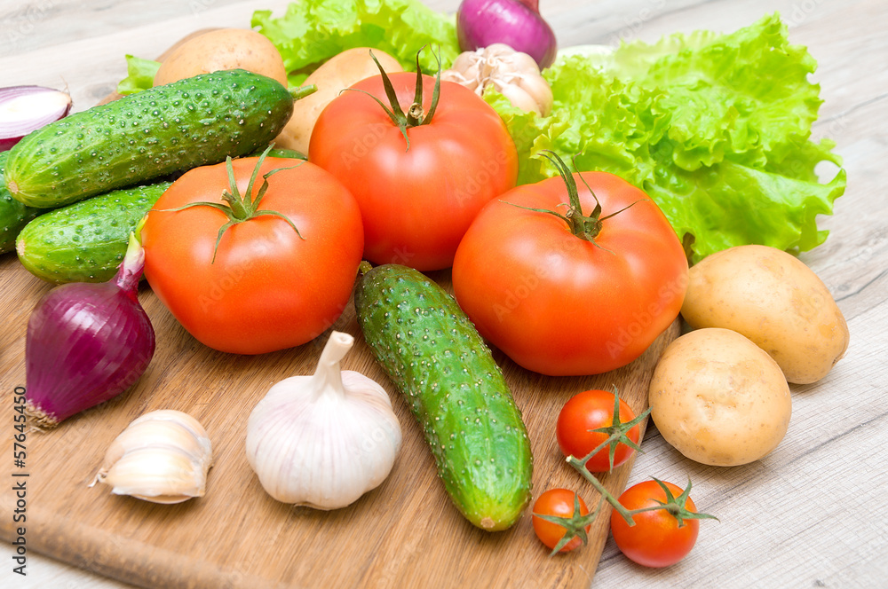 fresh vegetables on a cutting board on a wooden table close up fresh vegetables on a cutting board on a wooden table close up