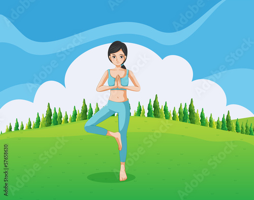 A slim lady doing yoga at the hill