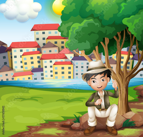 A man sitting above the rock under the tree