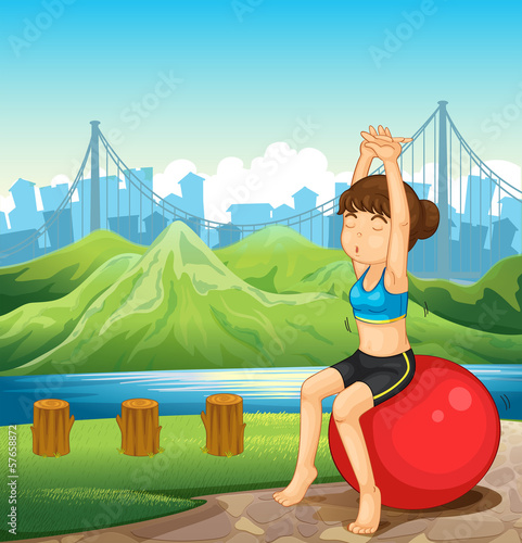 A girl exercising near the river across the mountains