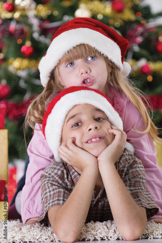 Portrait of happy boy laughing in his sister embrace on Christma Portrait of happy boy laughing in his sister embrace on Christma