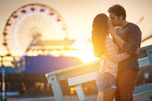 romantic couple kissing in front of santa monica