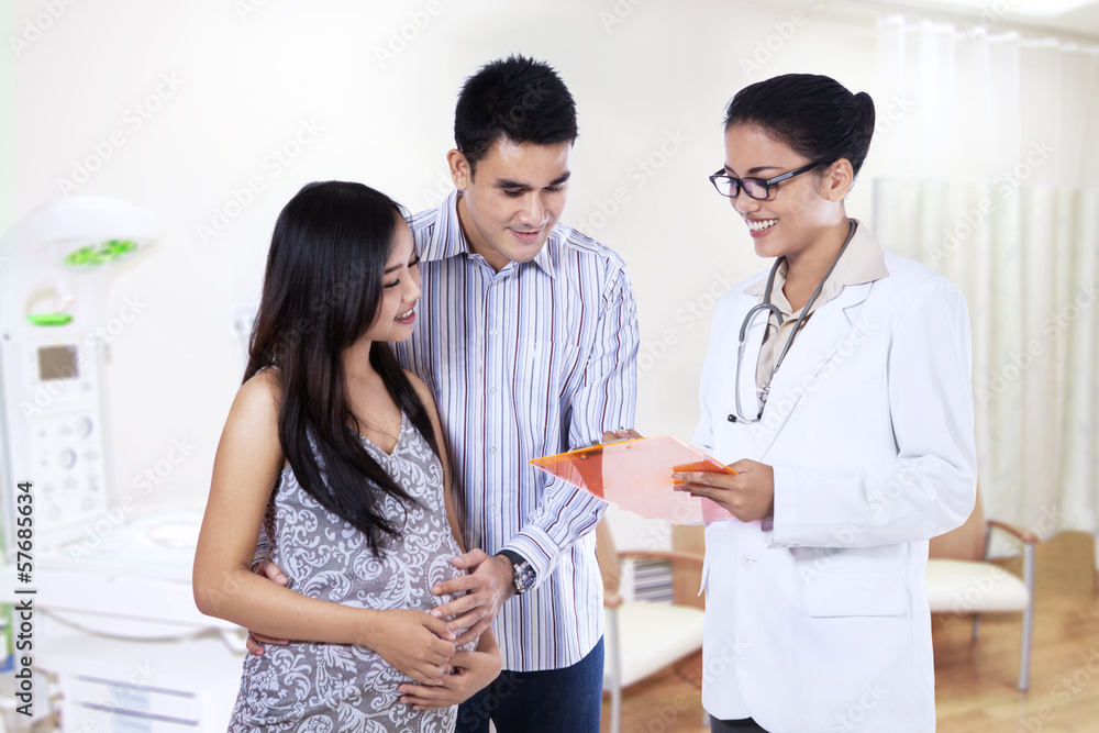 Fototapeta premium Pregnant couple visiting a female doctor