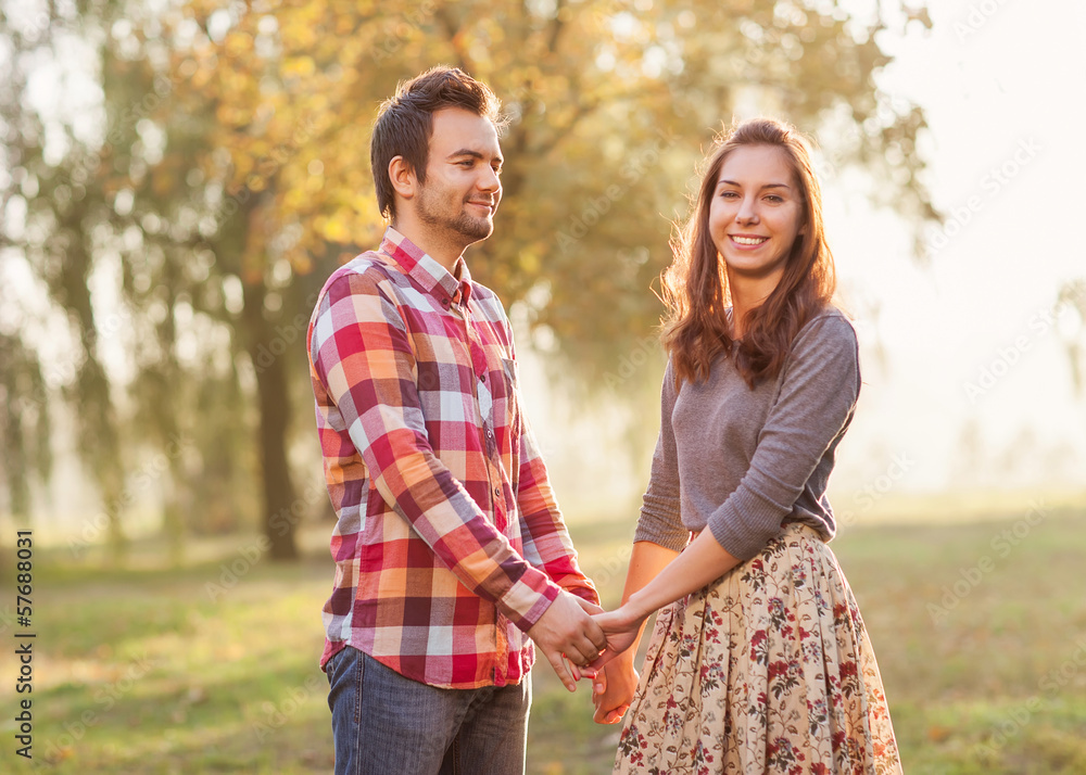 Young couple in love walking in the autumn park near the river. Young couple in love walking in the autumn park near the river.