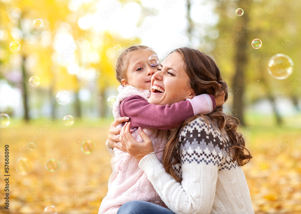 Obraz premium Mother and daughter having fun in the autumn park