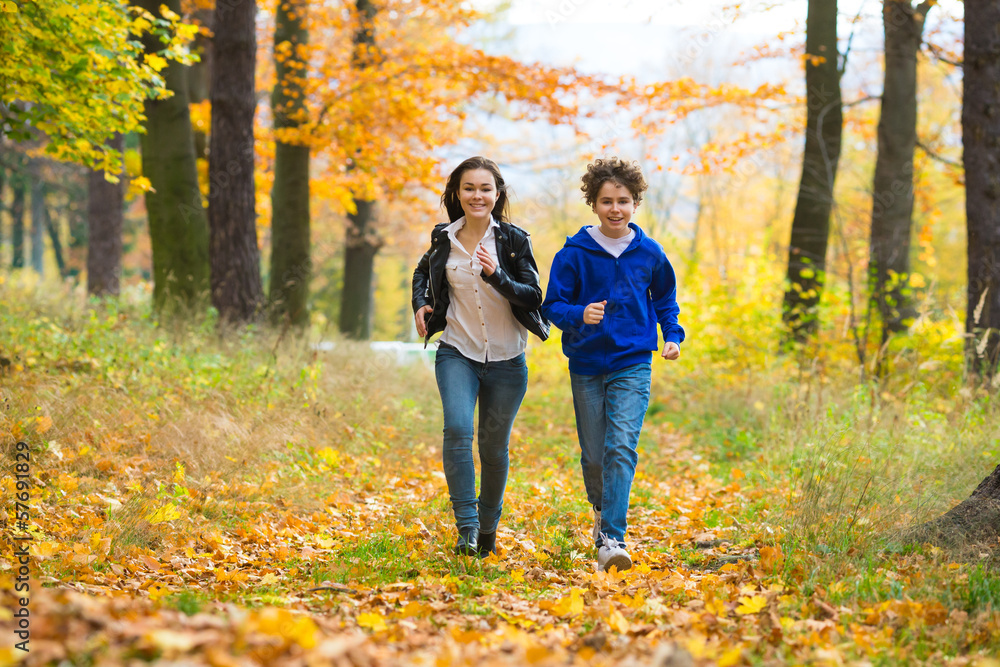 Girl and boy running, jumping in park Girl and boy running, jumping in park