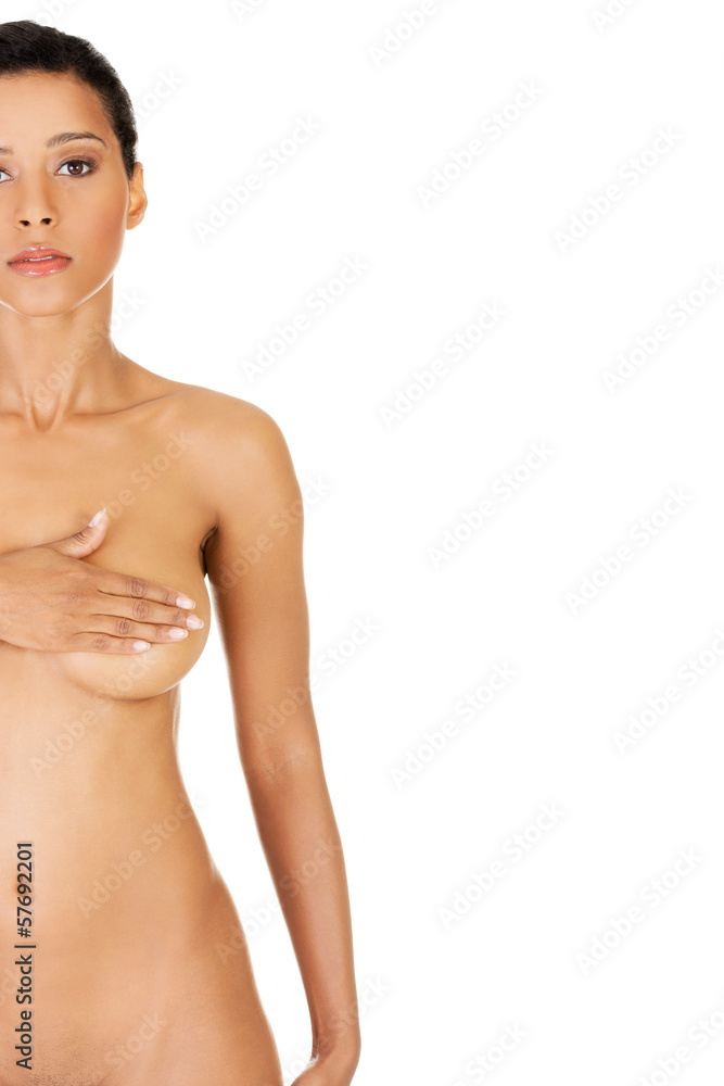 Young woman doing self brast examination, holdin her breasts.