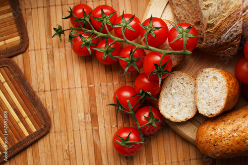 Tomatoes and breadon the wooden mat photo