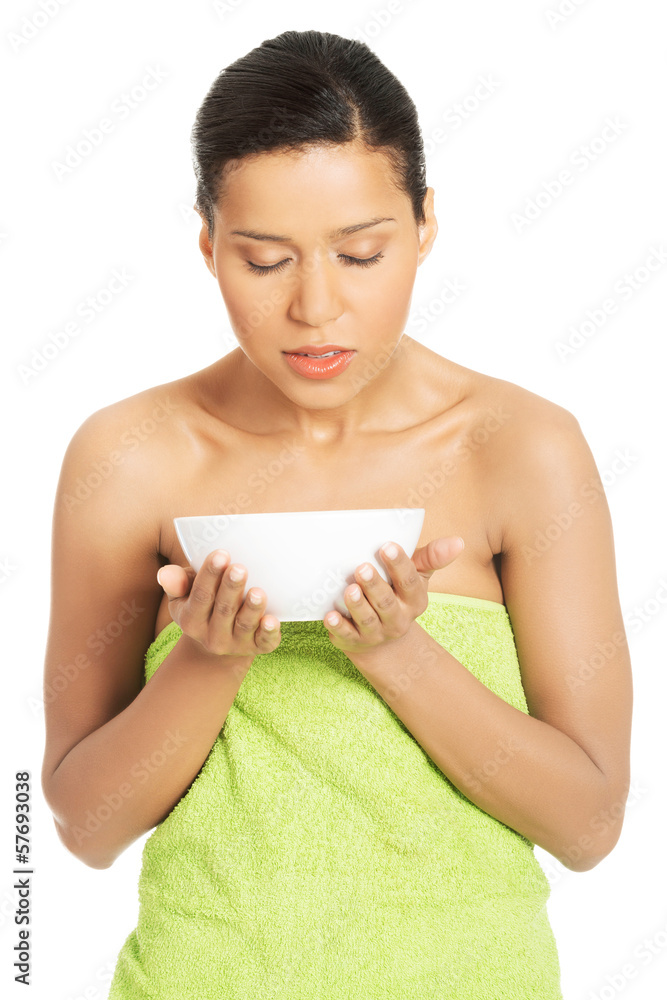 Beautiful and young woman wrapped in towel is holding a bowl and Beautiful and young woman wrapped in towel is holding a bowl and