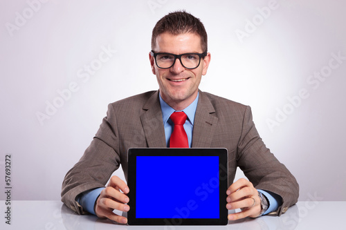 young business man holds a tablet at his desk