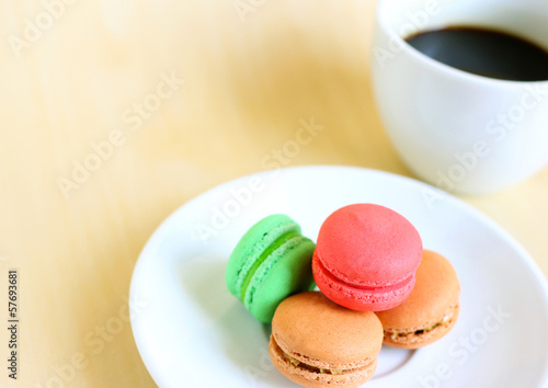 Colorful macaroons and a cup of coffee with copy space