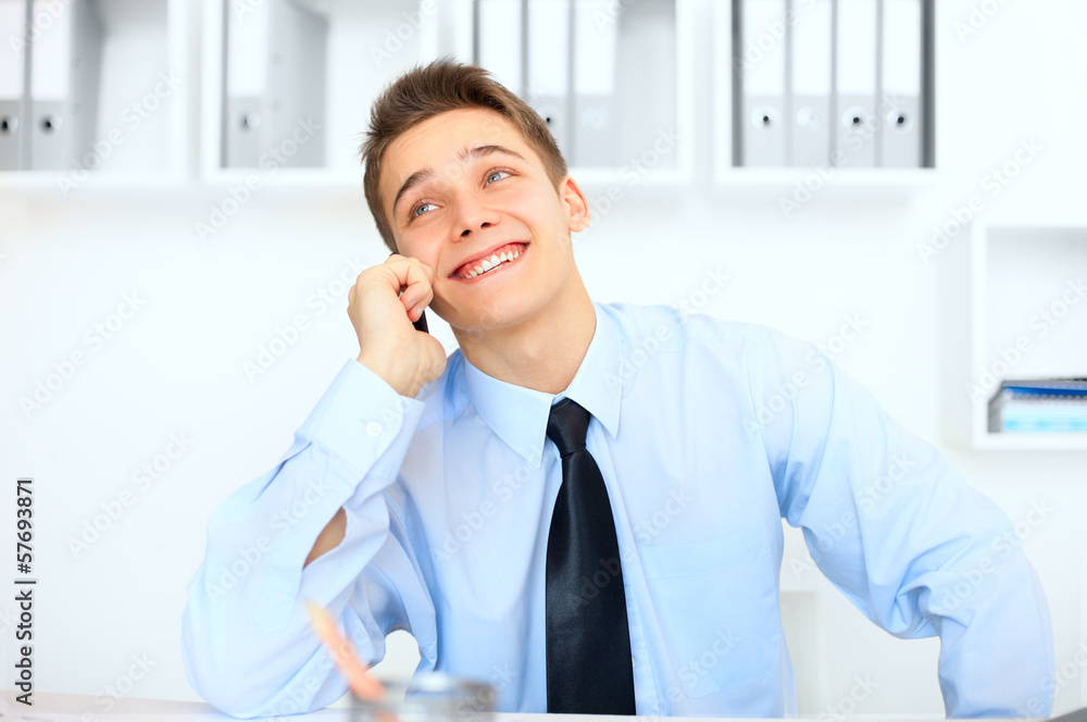Young laughing businessman talking on cell phone Young laughing businessman talking on cell phone