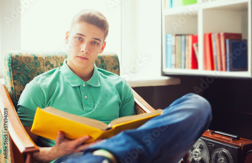 Student reading book at home
