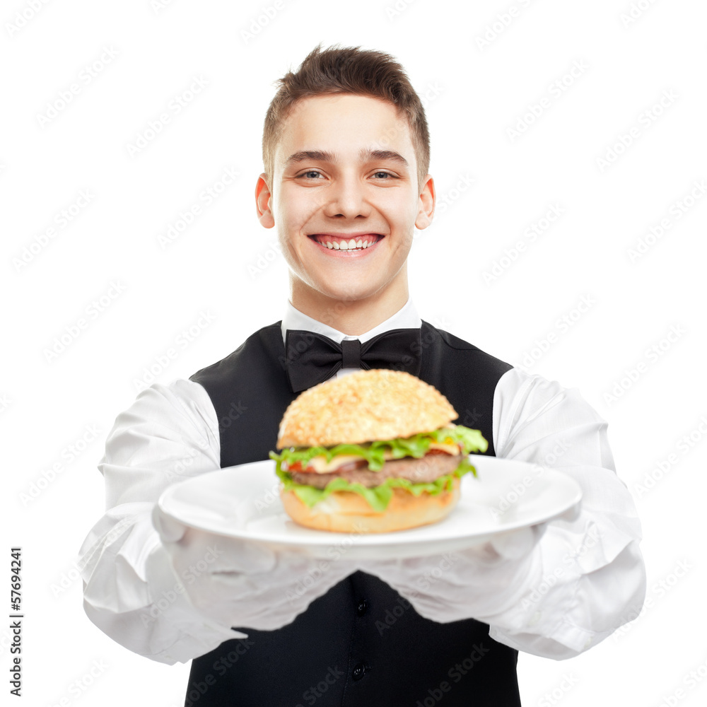 Young happy smiling waiter holding hamburger on plate